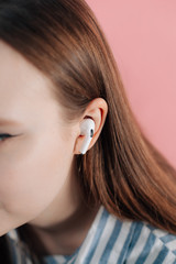 girl uses wireless white headphones on a pink backgroud. new air pods pro
