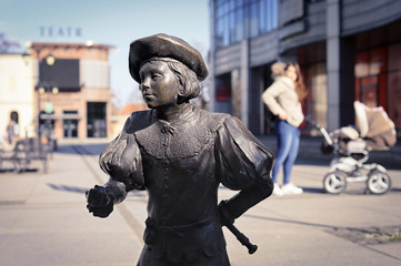 Inowroclaw, Poland - bronze figure of a medieval student in the city center with a bokeh background