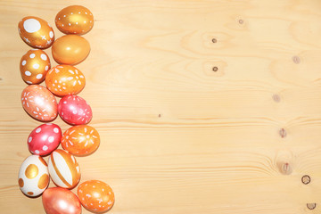 Decorated golden easter eggs on trendy wooden background. Minimal holiday concept. Happy Easter background, place for text, postcard, banner for the screen.
