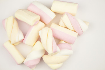 Marshmallow multicolored. Meringue marshmallows in a green cup on a light background. Colorful...