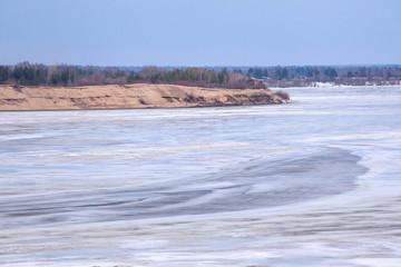 winter landscape with river in spring day before ice drift