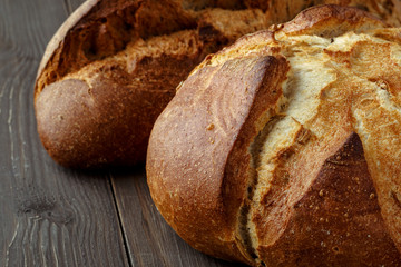Freshly baked traditional bread on wooden table, with copy space, food closeup. Whole grain rye bread with seeds