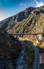 Fototapeta na wymiar The mountain river along the Road, Aerial panoramic drone view of a scenic highway by the beautiful Landscape covered in clouds and fog, bridge and viaduct, The mountain river along the road,