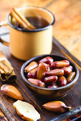 Glass of quentão, a typical drink from Brazil, in the state of Minas Gerais, with a portion of pine nuts. Brazilian food from traditional June parties and Brazilian invention.