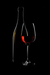 Wine glass with bottle on a black background