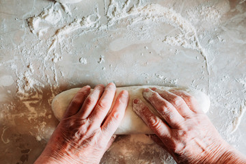 Fototapeta premium Female hands kneading raw homemade bread loafs on the table. Homemade cooking