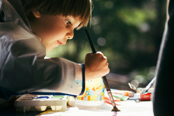 Fototapeta Niño haciendo actividades artisticas con pincel y pinturas obraz