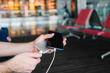 Hands connect power bank cable to smartphone
