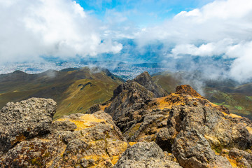 The peaks of the Rucu Pichincha volcano in the Andes mountains with the aerial view over Quito city 2000m lower, Ecuador.