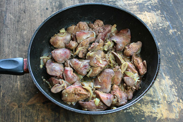 Fried livers with onions in a black pan