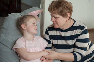 Grandmother 60 years old and granddaughter together at home. Take care of your family, stay home, coronovirus