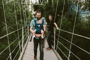 Baby girl being carried by her father in a carrier
