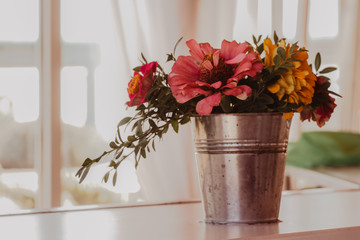 Pink and yellow flowers in the bucket