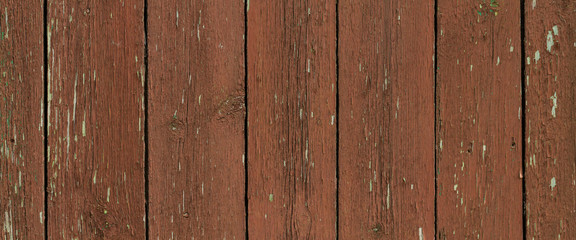 The wooden background with vertical planks with old paint. Textured surface.