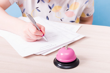 a woman in a sweatshirt signs a contract, in the foreground is a pink service call, go to work in the service sector, sign papers for employment, find a job, find employees, official employment