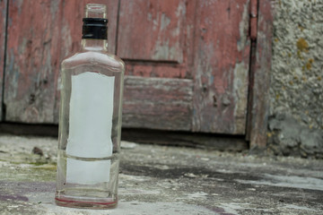 empty bottle on the background of worn, cracked doors, desolation