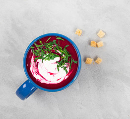 Beet soup puree in a mug on a light background top view