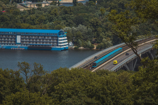 New metro train in Kiev is running over the bridge over Dnieper river towards Hydropark and Dnipro district on a warm summer day in Ukraine.