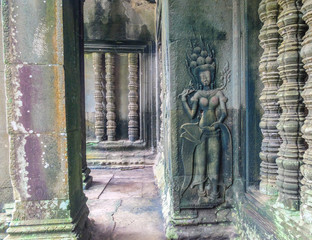 Dancing apsara and colons, an old ornament on the ancient wall, and entrance in the ancient monument, Angkor Wat, Cambodia