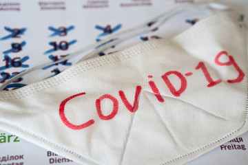 the respirator lies on calendar with marks. Concept of the raging coronavirus pandemic in 2020