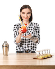 Beautiful female bartender at table against white background