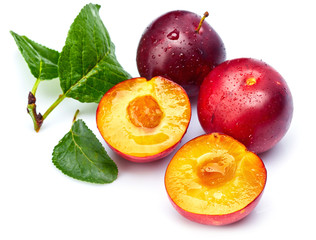 Fresh plum in cut with green leaf. Fruity still life. Healthy food. Isolated on white background.