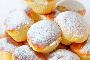 Homemade small Easter cakes sprinkled with powdered sugar on a white background