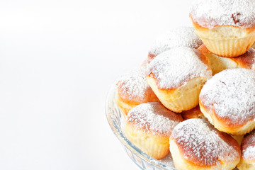 Homemade small Easter cakes sprinkled with powdered sugar on a white background