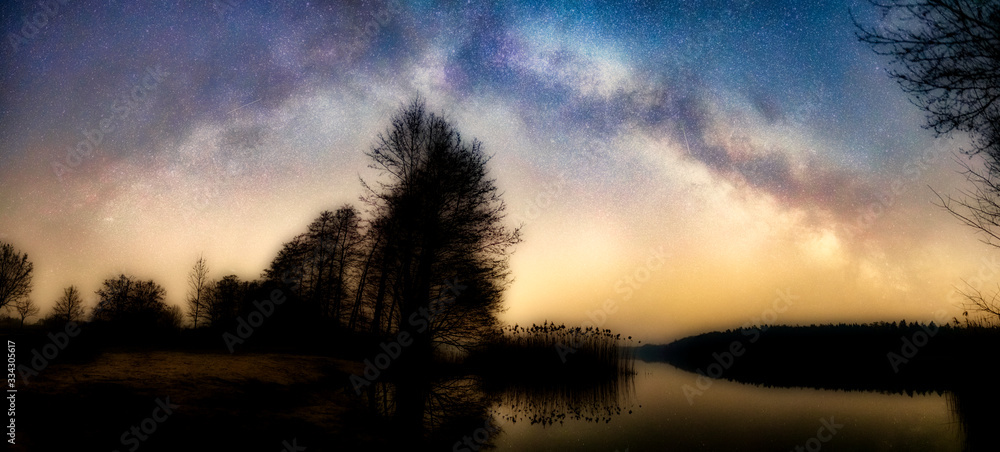 Wall mural special orton effect, beautiful colorful panoramic photo of the milky way over a lake and a tree on 