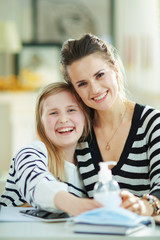 smiling young mother and daughter showing hands disinfectant