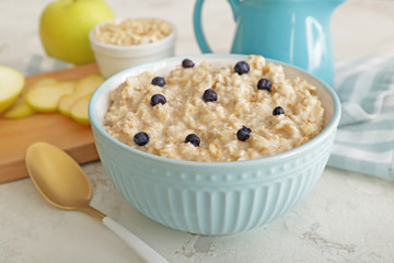 Bowl with tasty sweet oatmeal on table