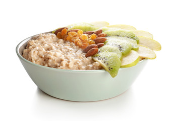 Bowl with tasty sweet oatmeal on white background