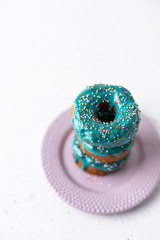 Puff pastry donuts cronuts with blue icing on white background