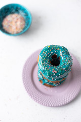 Puff pastry donuts cronuts with blue icing on white background