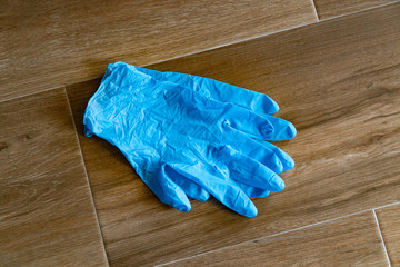 Coronavirus COVID-19 Infection control concept. Discarded lying on the floor blue disposable gloves...