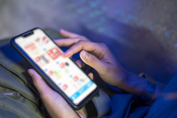 Woman hands holding smart phone with shopping screen for online shopping