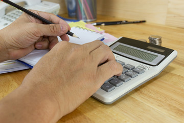 businessman use a calculator to calculate income and expenses in the office concepts, accounting, finance, investment