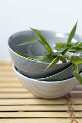 Empty bowls with bamboo leaves on bamboo background. Asian style
