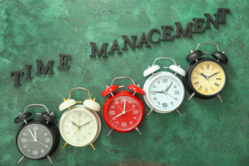 Alarm clocks with text TIME MANAGEMENT on color background