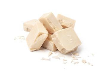 White chocolate cut into a square with crumbs on a white background