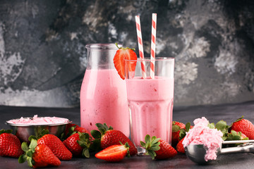 Glass of fresh strawberry shake, smoothie or milkshake and fresh strawberries on table. Healthy food and drink concept