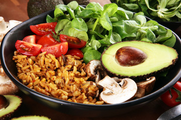 Healthy vegan salad bowl with quinoa, tomatoes, avocado and mixed greens, lettuce. Food and health bowl