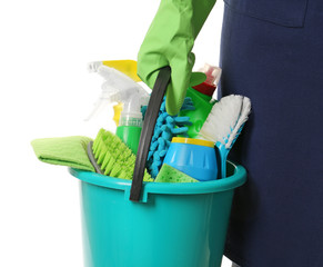 Female janitor with cleaning supplies in bucket on white background © Pixel-Shot
