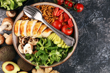 Healthy salad bowl with quinoa, tomatoes, chicken, avocado and mixed greens, lettuce. Food and health bowl