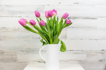 Pink tulips in a white ceramic vase