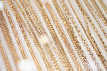 Gold chains and jewelry on a white counter.