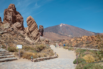 Tourists visiting the popular viewpoint close to Mount Teide and walking through the eroded rock...