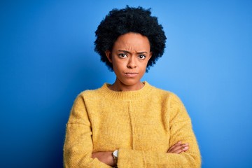 Fototapeta na wymiar Young beautiful African American afro woman with curly hair wearing yellow casual sweater skeptic and nervous, disapproving expression on face with crossed arms. Negative person.