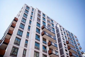 Beautifully designed multistory house with glass facade balconies in city district architecture, luxury real estate property apartments for sale.