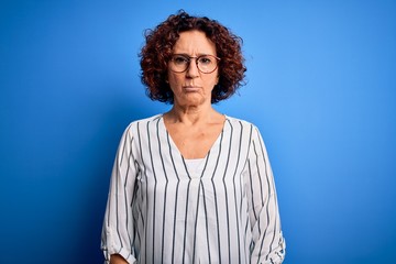Fototapeta na wymiar Middle age beautiful curly hair woman wearing casual striped shirt over isolated background depressed and worry for distress, crying angry and afraid. Sad expression.